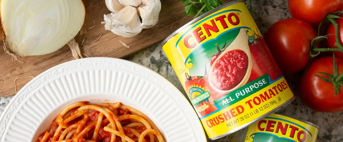 Cento Crushed Tomatoes in can on table with spaghetti